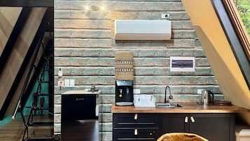 Una cucina moderna con parete in pietra, dispenser integrato per l'acqua e macchina del caffè.