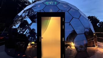 Una estructura esférica con superficie reflectante y una puerta.