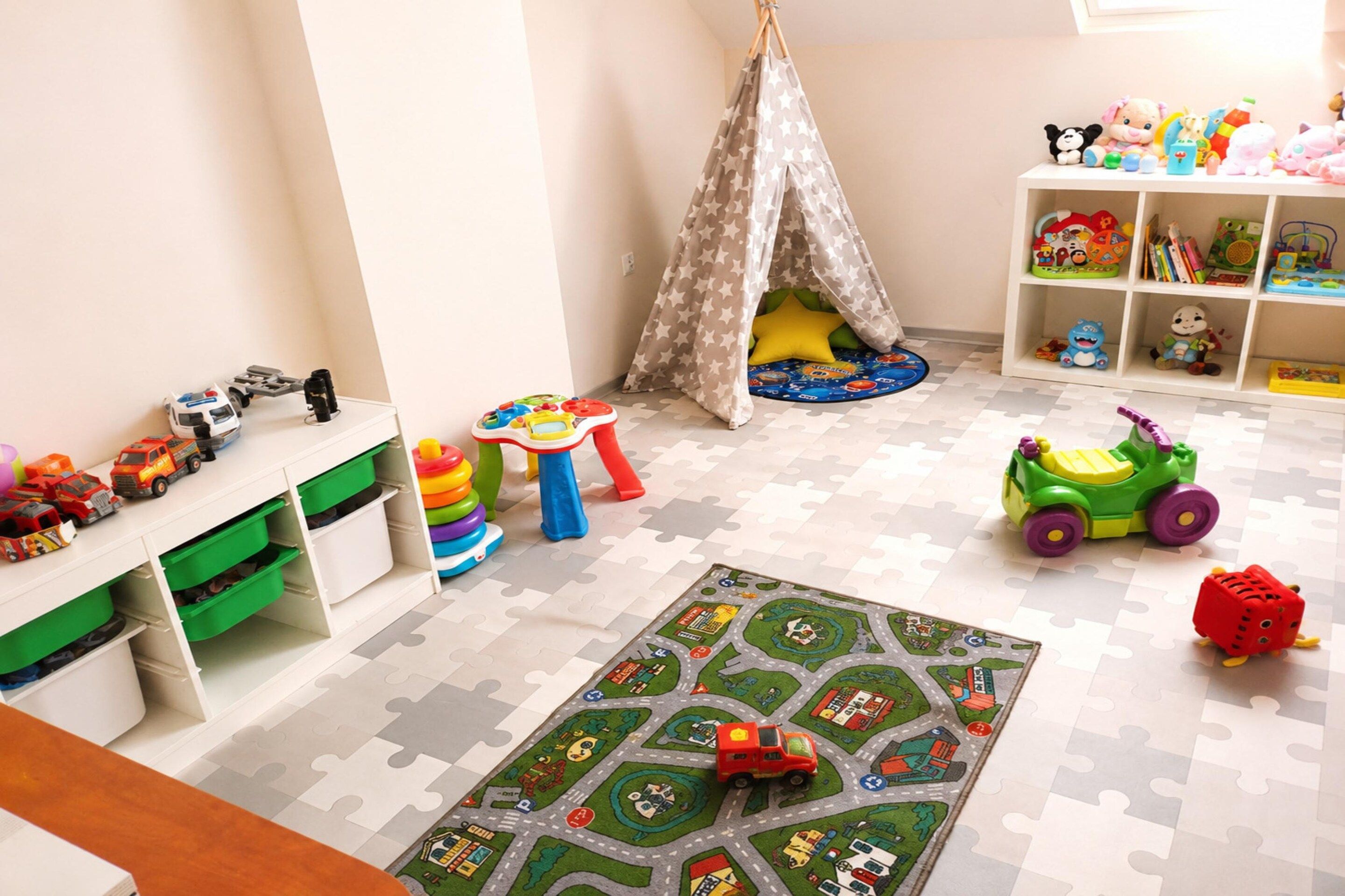 Ein Kinderzimmer mit Puzzleteppich, Spielzeug und Stauraumeinheiten.
