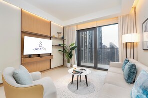 A modern living room with a flat-screen TV, a sofa, a coffee table, and a large window with curtains. - bnbme - Address Opera T 1 - BR (Dubai)