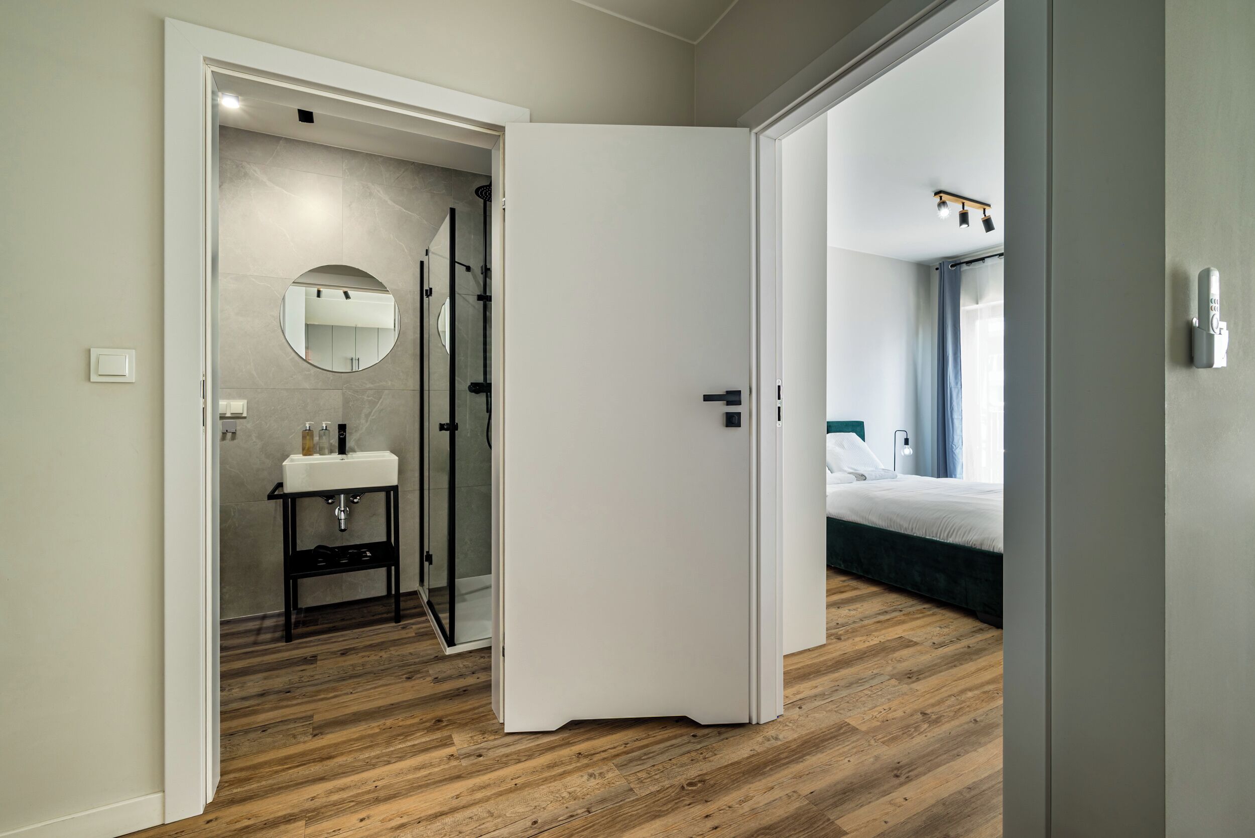 Een moderne badkamer met spiegel, wastafel en douche.