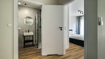 Een moderne badkamer met spiegel, wastafel en douche.