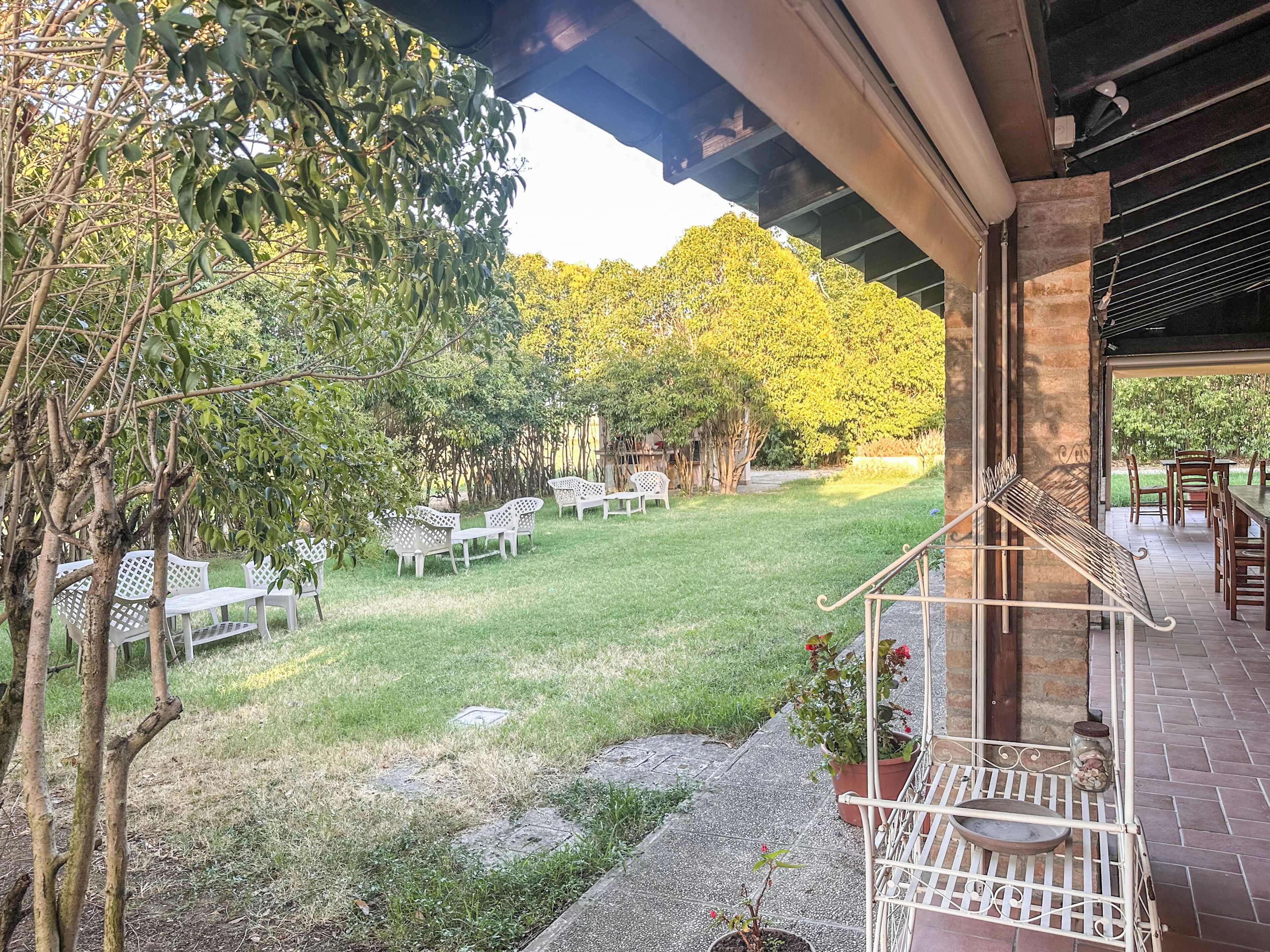 A patio area with outdoor seating, a small garden, and a view of the surrounding trees.