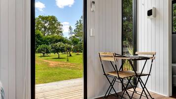 A room with a sliding glass door leading to an outdoor area with a table and chairs.