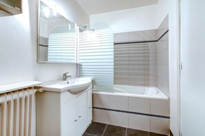 A bathroom with a white sink, mirror, and a glass shower enclosure. - Chic 1BR by Louvre & Palais Royal (Paris)