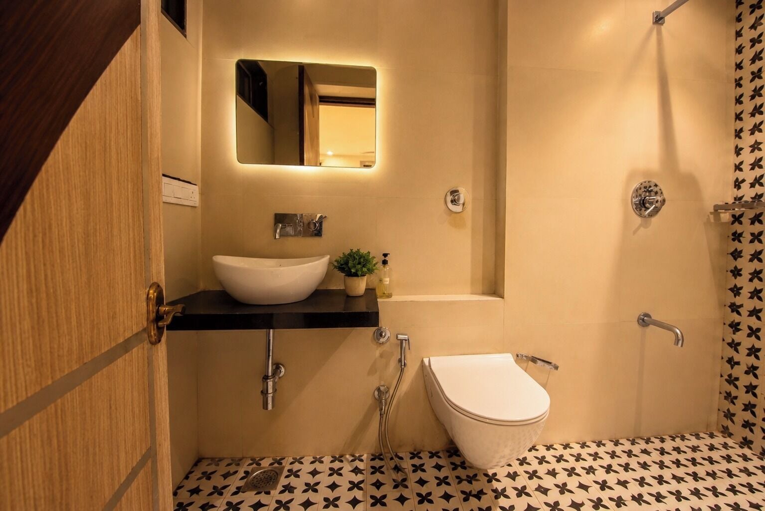 A bathroom with a white sink, a mirror, a shower, and a toilet.