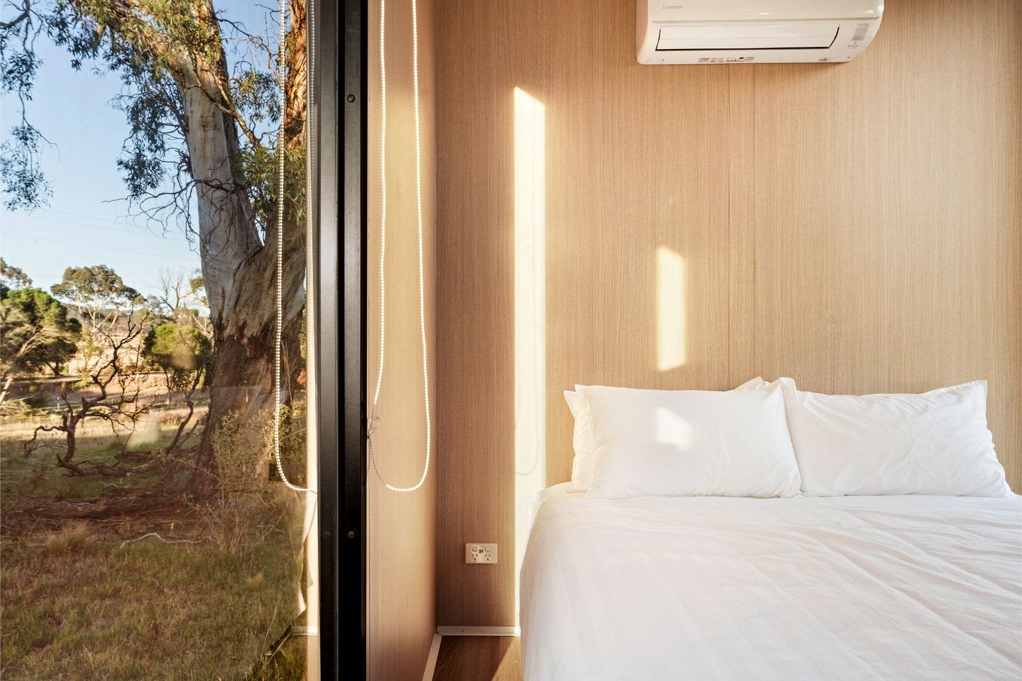Ein Schlafzimmer mit Bett, Fenster und Klimaanlage.