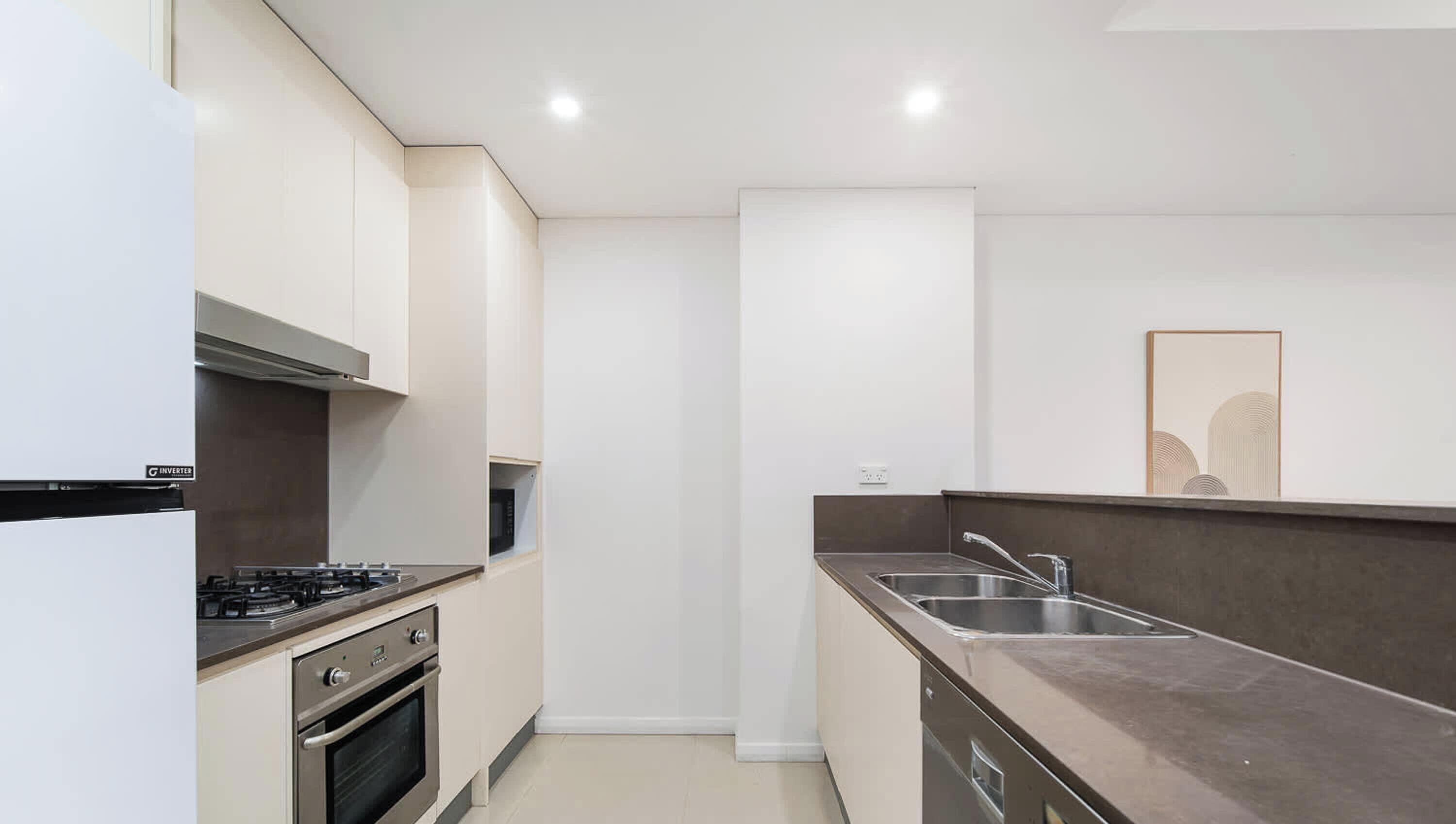 A modern kitchen with a gas stove, oven, and stainless steel sink.