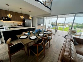 Una cocina moderna con comedor, ventanas amplias y vistas al exterior.