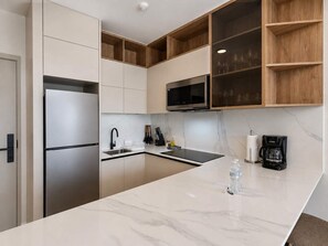 A modern kitchen with a built-in refrigerator, microwave, and a coffee maker. - w Cozy 1BR w Balcony View in San Francisco (Panama City)