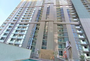 A high-rise residential building with multiple balconies, a central courtyard, and a swimming pool area. - Sobha Creek Vistas Reserve Tower A (Dubai)