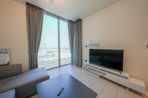 Ein modernes Wohnzimmer mit großem Flachbildfernseher, einer Couch und einem Couchtisch.