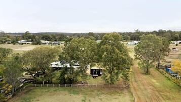 Landgoed op het platteland met omheinde tuin, een klein gebouwtje en verspreide bomen.