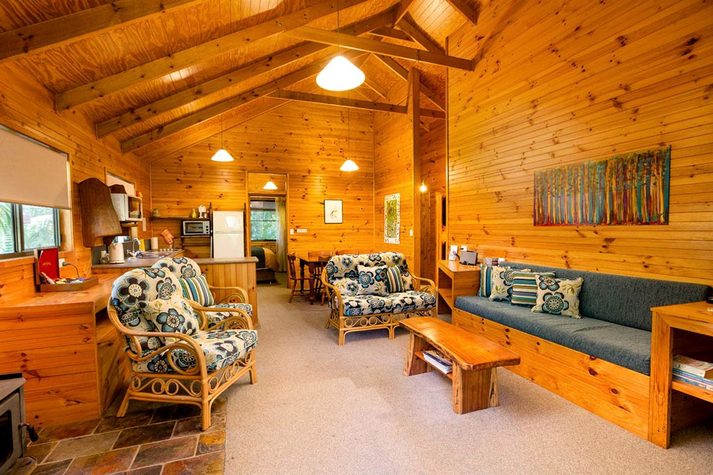 Un intérieur de chalet chaleureux avec une cheminée, des meubles en bois et un coin repas.