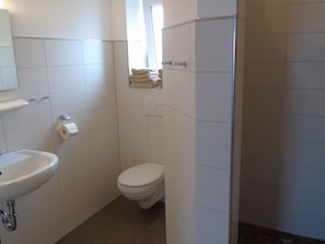 A small, clean bathroom with a toilet, sink, and towel rack. - Staying Overnight at the Winery (Bretzfeld)
