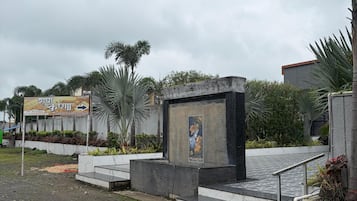 A paved area with a concrete structure, a metal railing, and a poster on the wall.