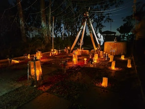 An outdoor setting with a tent, candles, and a table set up for an event.