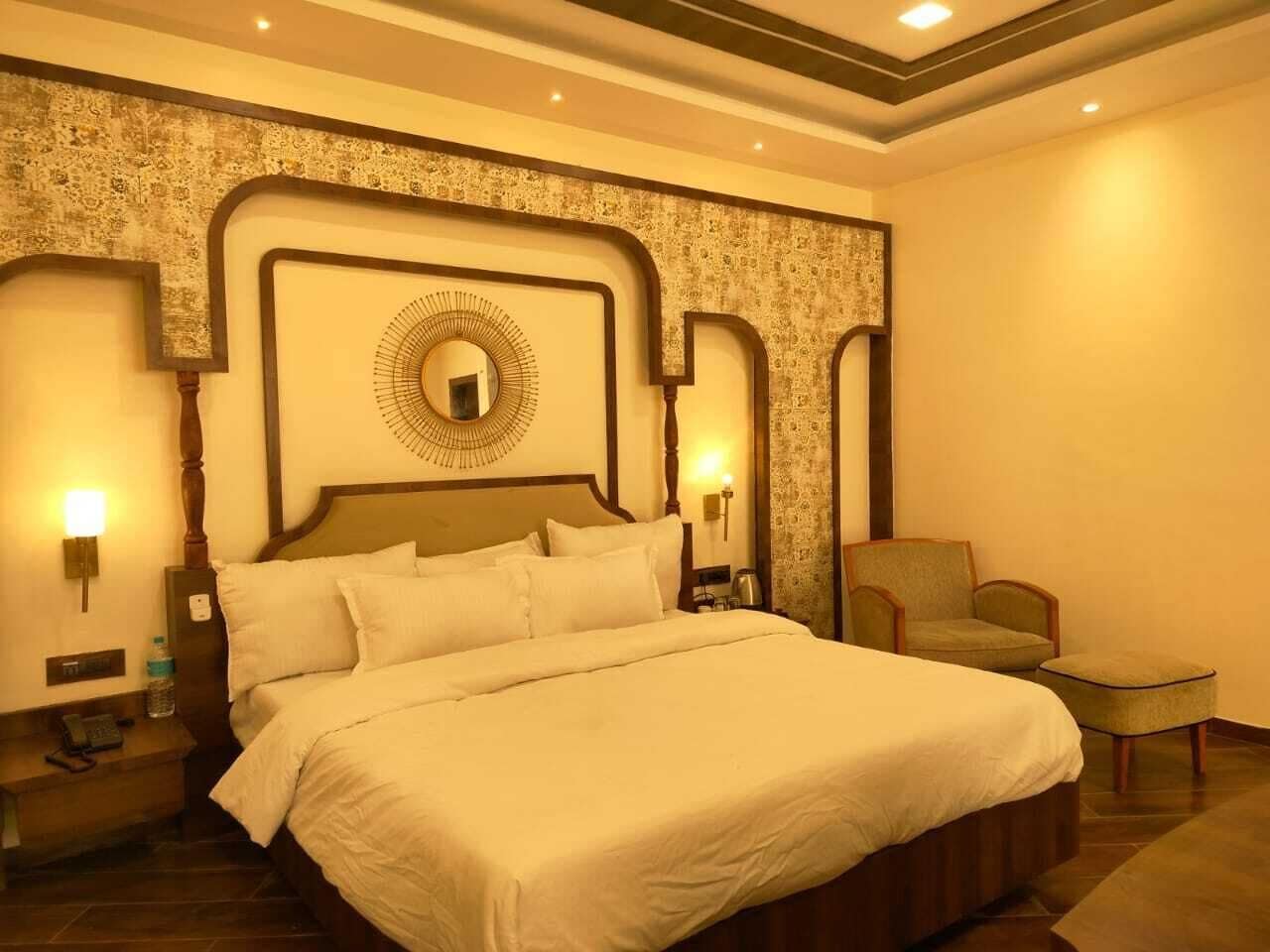 Een hotelkamer met een groot bed, een nachtkastje, een stoel en een spiegel aan de muur.