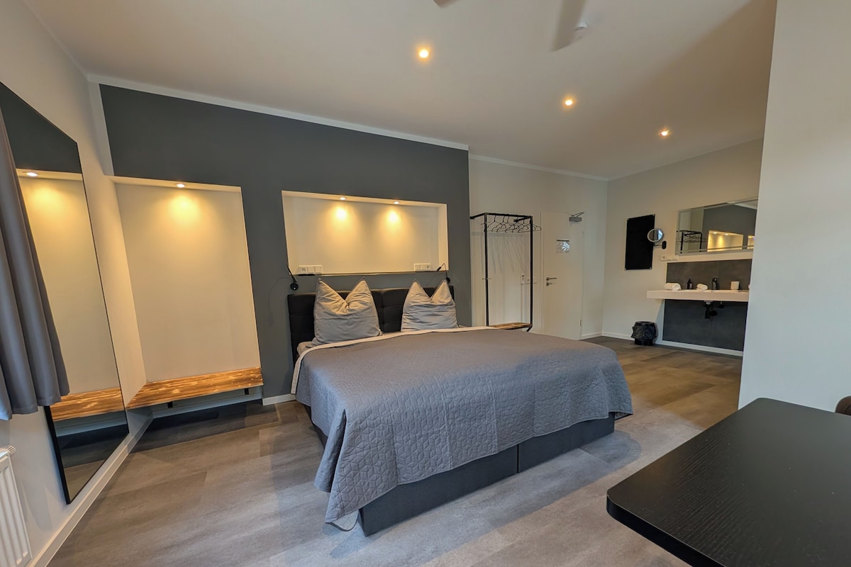 A modern bedroom with a large bed, bedside tables, and a built-in wardrobe.