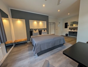 A modern bedroom with a large bed, bedside tables, and a built-in wardrobe.