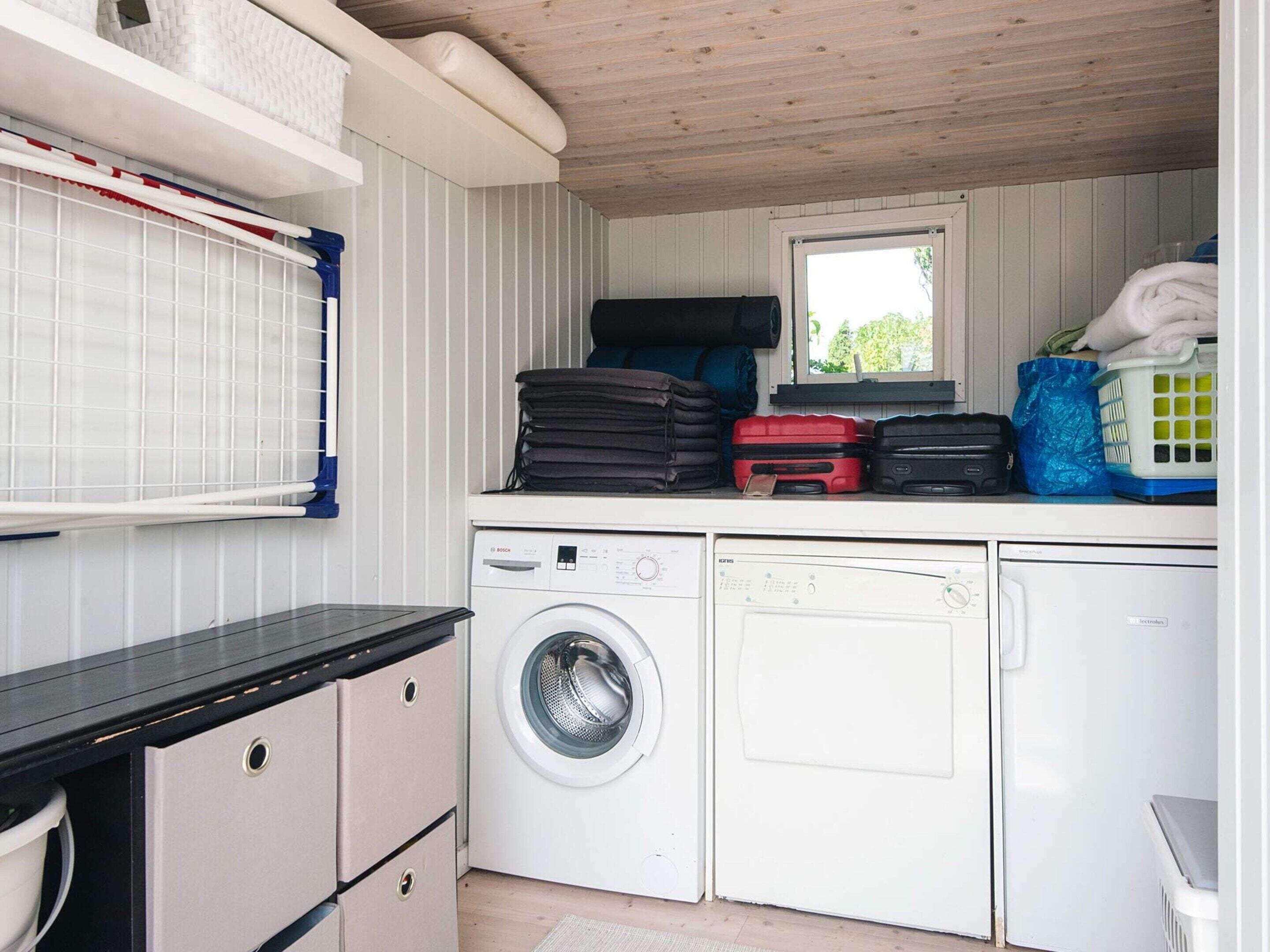 A compact laundry area with a washing machine, a dryer, and a window.