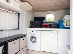 A compact laundry area with a washing machine, a dryer, and a window. - 4 Star Holiday Home in Juelsminde (Juelsminde)