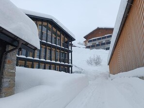 Un edificio cubierto de nieve con un balcón y fachada de madera.