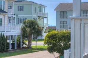 A residential area with multi-story houses featuring balconies and a central palm tree.