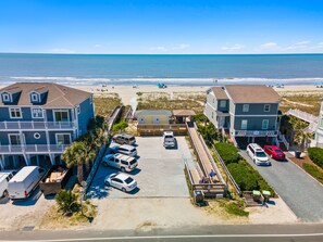 A coastal property with a parking area, beach access, and ocean views.