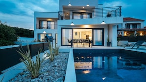 A modern two-story house with a swimming pool, outdoor seating, and a dining area. - Villa Anamaria Zadarvillas (Zadar)