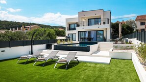 A modern two-story house with a swimming pool, outdoor seating, and a view of the surrounding area. - Villa Anamaria Zadarvillas (Zadar)