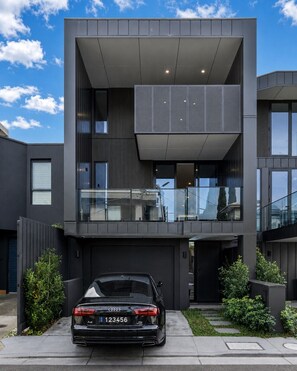 A modern two-story building with a car parked in front. - The Richmond Grand | Near MCG + 3 Free Car Spaces (Richmond)