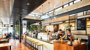 Een modern café interieur met een bar, zitplaatsen en een menubord.