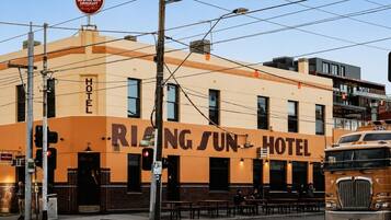 A building with a sign reading 'RING SUN HOTEL' and a 'Carlton DRAUGHT' sign above it.