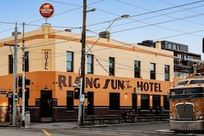 Ein Gebäude mit einem Schild, auf dem 'RING SUN HOTEL' steht, und einem 'Carlton DRAUGHT'-Schild darüber.