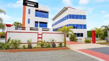 A modern townhouse with a sign indicating it is serviced by OYO.