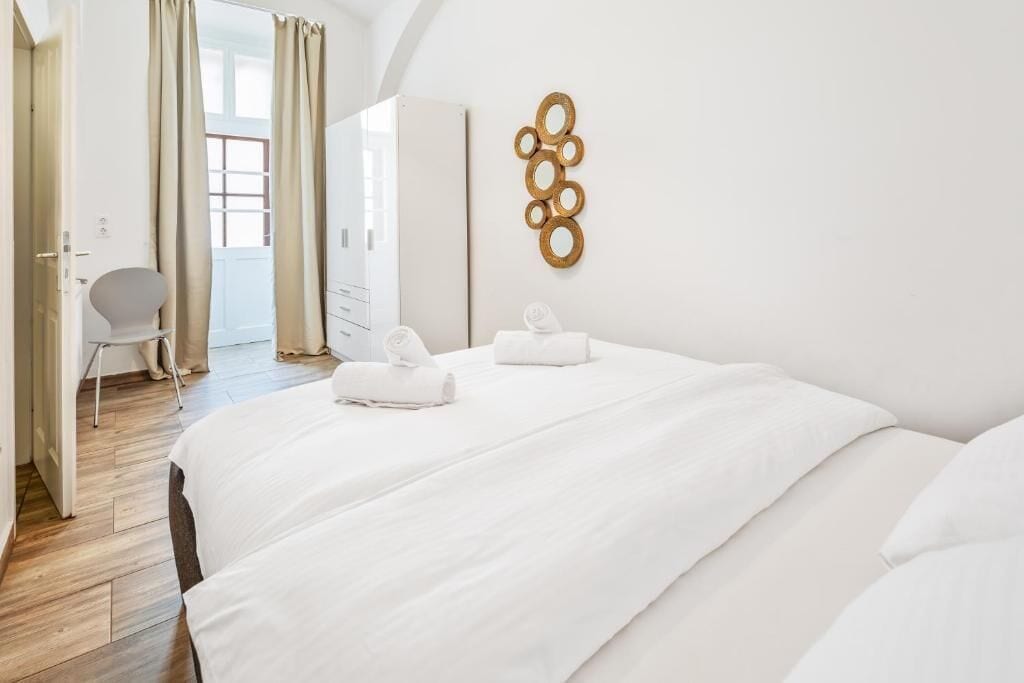 Hotelkamer met een groot bed, een stoel en een decoratief object aan de muur.