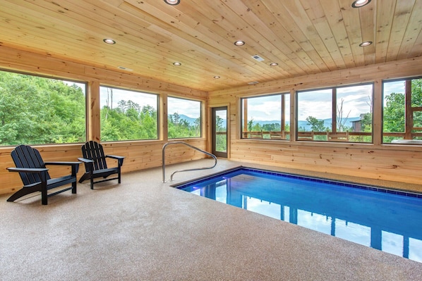 A wooden cabin with a pool, Adirondack chairs, and large windows. - Jump on Inn to this luxurious new pool cabin. (Sevierville)