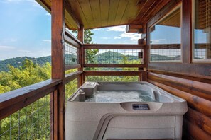 A wooden cabin with a hot tub and a view of the mountains. - One Bedroom 2 Story Log Cabin with Panoramic Views! (Sevierville)