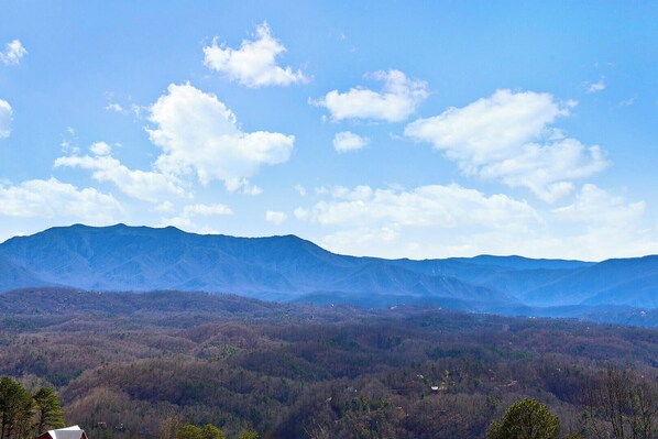 A mountainous landscape with a clear sky and scattered clouds. - One Bedroom 2 Story Log Cabin with Panoramic Views! (Sevierville)