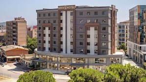 Un hotel de varios pisos con diseño moderno, que destaca por su entrada principal y un cartel con el nombre visible.