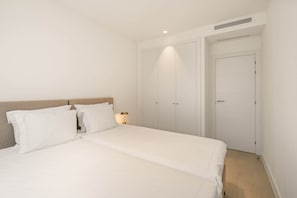Ein Schlafzimmer mit einem Bett, zwei Nachttischen, einem Schrank und einem Kleiderschrank.