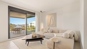 A modern living room with a large sliding glass door leading to an outdoor patio. - RDR577 - Designer 2-Bed with Garden in Camarate Hills (Buenas Noches)