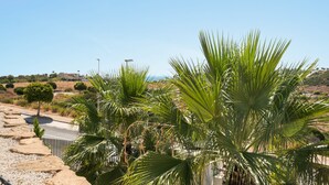 A paved pathway with palm trees and a clear blue sky. - RDR577 - Designer 2-Bed with Garden in Camarate Hills (Buenas Noches)