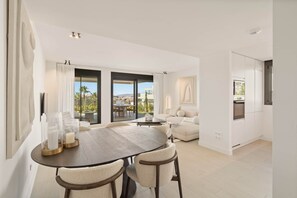 Ein modernes Wohnzimmer mit Essbereich, großen Fenstern und Blick auf die Stadtlandschaft.