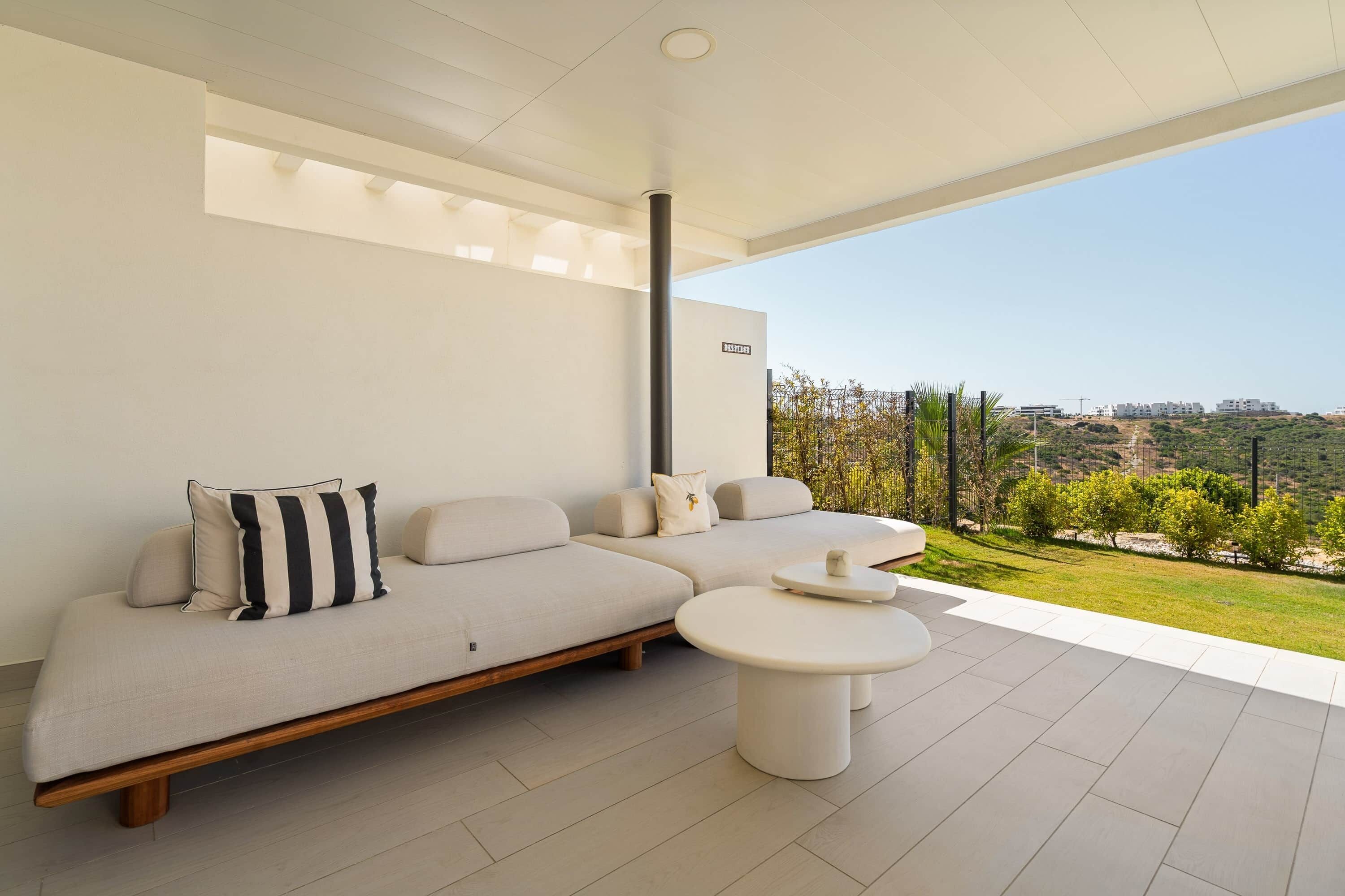 Una sala de estar moderna con un sofá, una mesita de centro y vistas a un paisaje verde.