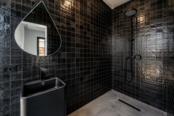 A modern bathroom with black tiled walls, a single sink, and a shower. - Villa with Pool, Jacuzzi, Sauna, and Hammam in Marrakech (Marrakech)
