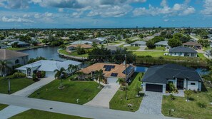 A residential area with houses, a body of water, and a clear sky. - Sleeps 8 - 2 bath- Pool and Hot Tub - Pet Friendly (Cape Coral)