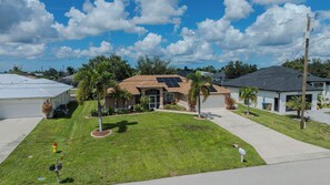 A residential area with houses, a well-maintained lawn, and a clear sky. - Sleeps 8 - 2 bath- Pool and Hot Tub - Pet Friendly (Cape Coral)