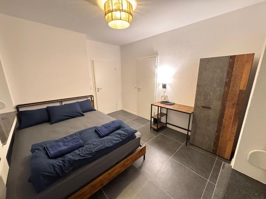 Ein Schlafzimmer mit Bett, Schreibtisch und Kleiderschrank.